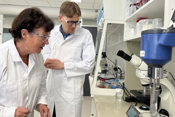 scientists checking asbestos contents in the lab. a woman and a man wearing glasses